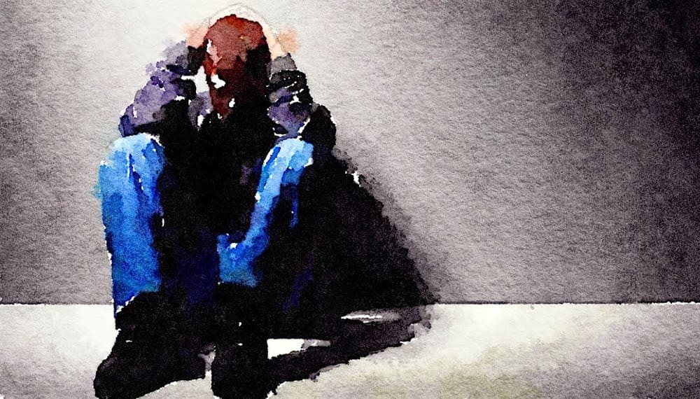 A boy sitting on the floor in jail