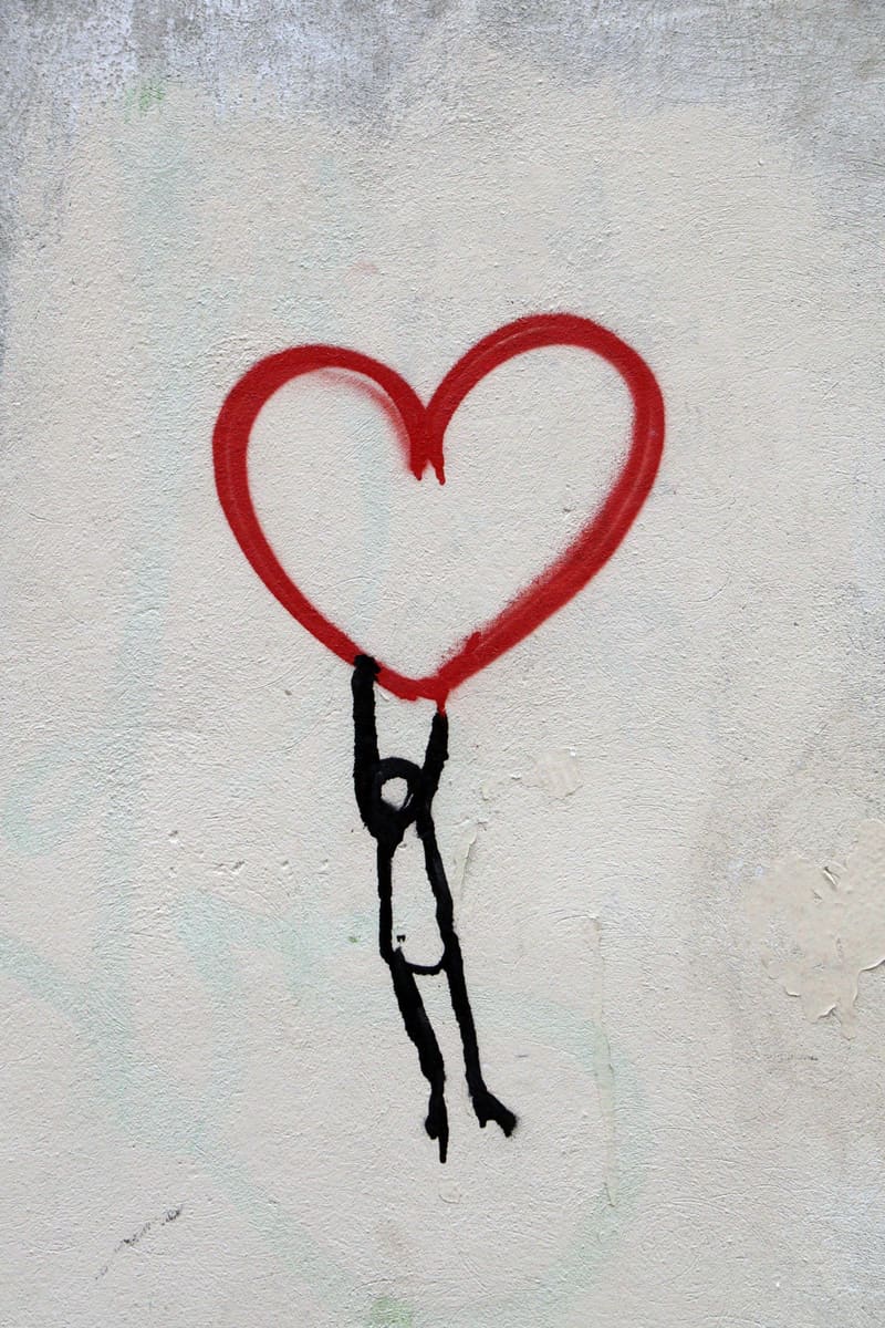 A stickman holding up a heart